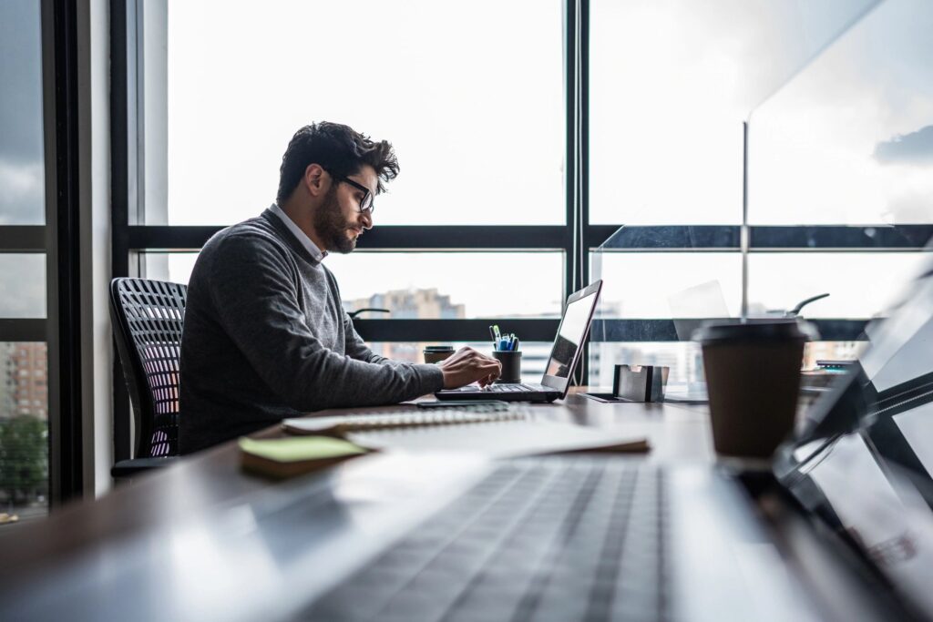 Mid adult businessman working using laptop at office